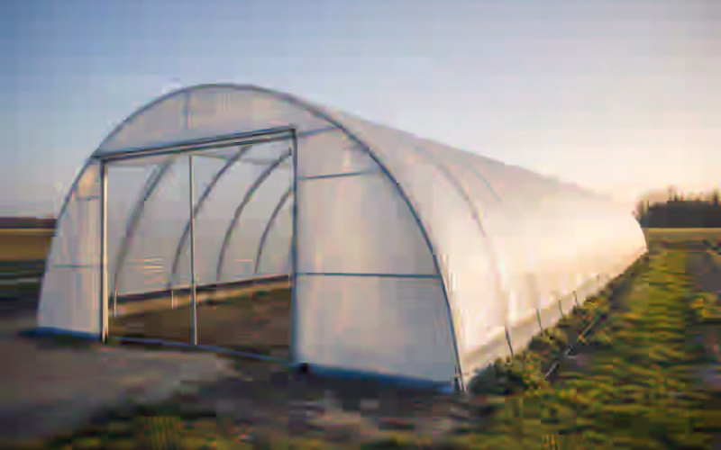 Serre tunnel maraîchère à double paroi gonflée montée en exploitation dans une plaine du Sud-Ouest, structure galvanisée et bâche tendue sous ciel clair